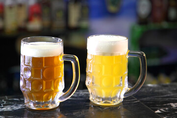 Glasses with different sorts of craft beer. Red, bronze and white beer in beer glasses on the bar. Glasses of light and dark beer on a pub background. 