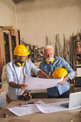 Carpenters at work analyzing blueprint