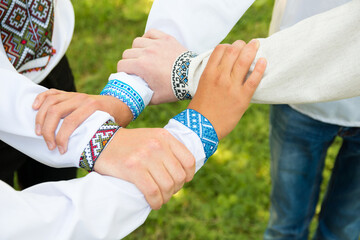 Four men's hands are intertwined. Guys in traditional Ukrainian embroidered shirts. A gesture that symbolizes unity.
Independence Day of Ukraine.