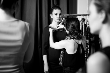 Fototapeta na wymiar Plus size model get prepared to runway fashion show by make up artist. Black and white backstage concept
