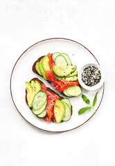 Avocado salmon toasts  served on a dish, top down view