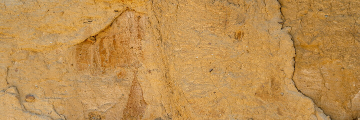 Background, a natural sandstone wall on a seaside cliff. Sandstone overlay