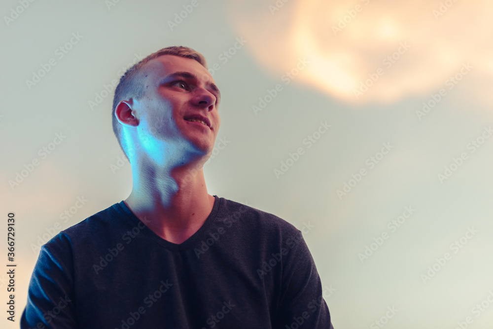 Wall mural Portrait of young blond man against beautiful view of the sky