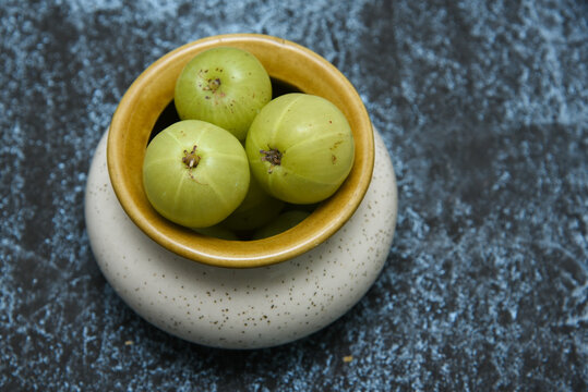 Indian gooseberries or Amla many with leaves, background. Amla fruit has antiviral and antimicrobial. properties. Used in ayurvedic medicines. heap of Green colour fruits
