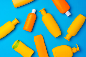 Bottles of sunscreen cream on blue background