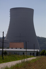 A cooling tower of a nuclear power plant. In the foreground some smaller houses.