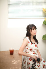 Portrait of Asian young woman with camera in coffee shop