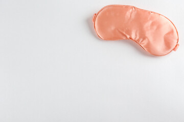 Top view shot of sleeping mask isolated on bright background. Close up, copy space, flat lay.