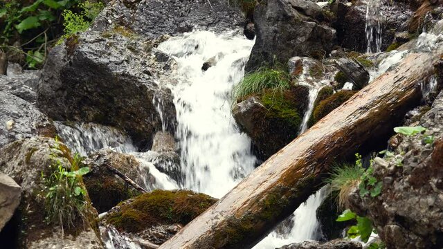 Mountain stream or waterfall flowing between rocks and stones. Foamy Valley Waterfall in Bucegi mountains accessible from Busteni town.