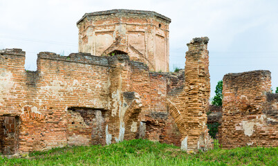 The ruins of the monastery in Biaroza, Belarus. The remains of the building. Brick destroyed walls. Red brick. Green grass around. 