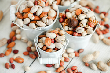 Fototapeta na wymiar Assorted nuts for a background Almond, walnut,cashew, pistachios, hazelnuts, peanuts, Macadamia Collection of different varieties of nuts. Composition with dried fruits Healthy food. Organic.
