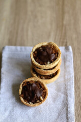 Pastry baskets filled with apples, almonds and dark chocolate. Selective focus.