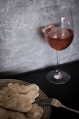 glass of wine and a plate (pierogi)