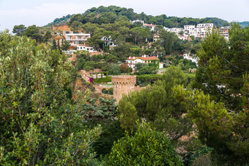 Fototapeta na wymiar The town of Tossa de Mar from above. City through a pine forest. City on the mountain. City from the top of the fortress.