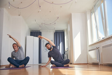Two flexible Caucasian men practicing yoga together
