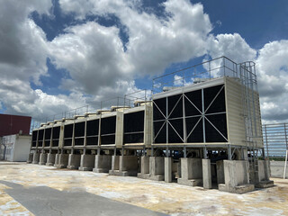 Fototapeta na wymiar Cooling tower machinery in large buildings That is clear sky With white clouds scattering the sky