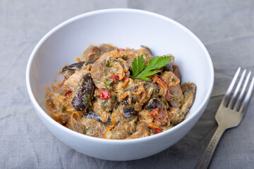 Pork with eggplant, tomatoes, peppers and carrots in a creamy sauce. Close-up.