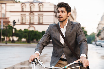 Young business man outdoors on a bicycle