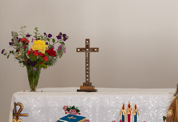 The decoratively decorated crucifix stands on a table in the Deir Al-Mukhraqa Carmelite Monastery building  in northern Israel - obrazy, fototapety, plakaty