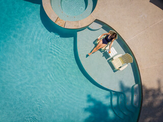Woman relaxing on vacation in resort pool 