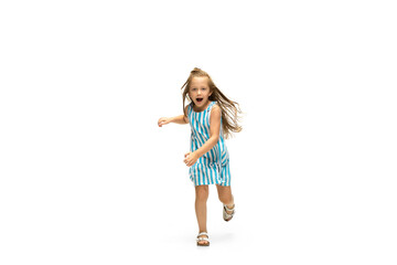 Happy child, little and emotional caucasian girl jumping and running isolated on white background. Looks happy, cheerful, sincere. Copyspace for ad. Childhood, education, happiness concept.