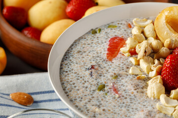 Chia pudding with strawberry and pumpkin seeds on wooden table