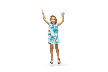 Happy child, little and emotional caucasian girl jumping and running isolated on white background. Looks happy, cheerful, sincere. Copyspace for ad. Childhood, education, happiness concept.