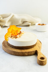 Raw almond cake with dried persimmon on a wooden board. Vegan dessert, healthy food. Sugar and lactose free.