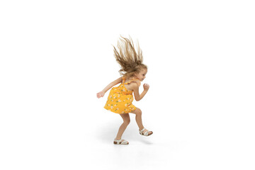 Happy child, little and emotional caucasian girl jumping and running isolated on white background. Looks happy, cheerful, sincere. Copyspace for ad. Childhood, education, happiness concept.