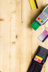 Payment by credit card. Terminal on wooden background top-down copy space