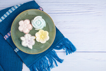 Top view of colorful coconut milk jelly on a plate on a blue cloth