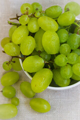 green grapes in a plate on a white background