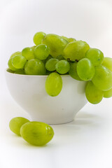 green grapes in a plate on a white background