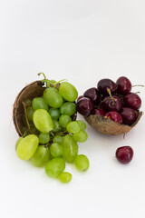 green grapes, cherries and coconut on a white background