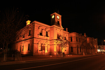 Fototapeta na wymiar The historic old Town Hall (built 1882) in Mount Gambier, South Australia, lit up at night. 