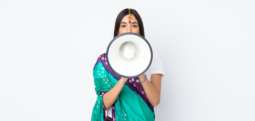 Young Indian woman isolated on white background shouting through a megaphone