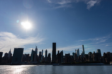 Bright Sun with a Midtown Manhattan Skyline Silhouette along the East River in New York City