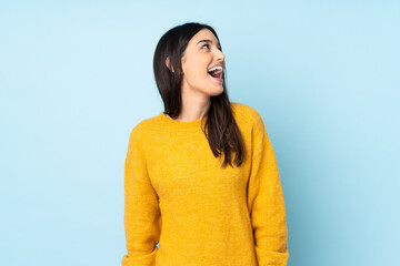 Young caucasian woman isolated on blue background laughing - obrazy, fototapety, plakaty
