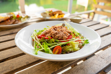 Restaurant serving food. Tuna salad in a plate on a table in a summer cafe