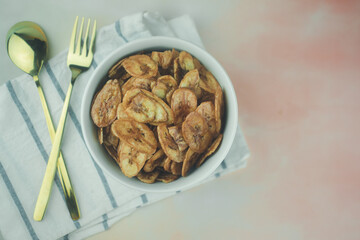 Homemade dehydrated banana chips cuisine fried in hot oil baked.