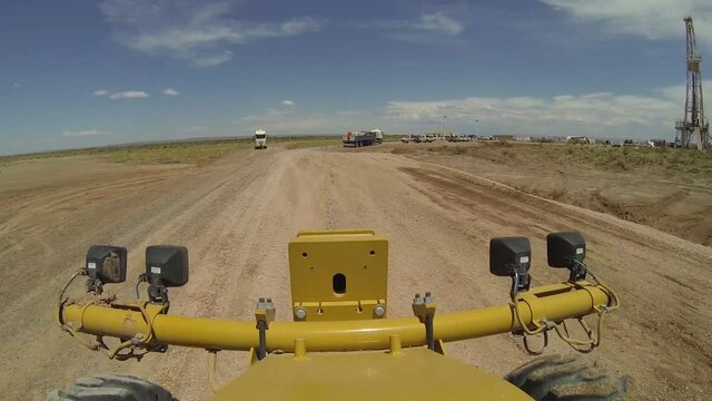 Vaca Muerta, Argentina, November 24, 2015: Motor grader working on dirt road, inside unconventional oil field. (Fracking).