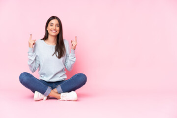 Young caucasian woman isolated on pink background pointing up a great idea