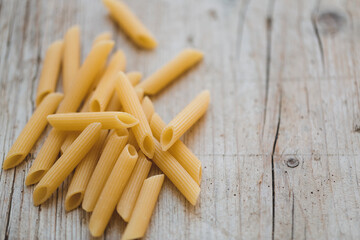 a lot of different kinds of egg noodles and yellow pasta on wooden background