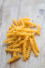 a lot of different kinds of egg noodles and yellow pasta on wooden background
