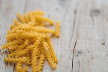 a lot of different kinds of egg noodles and yellow pasta on wooden background