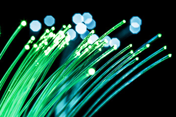 Bundle of optical fibers with green light. Black background.