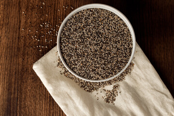 Bowl with raw chia seeds close up