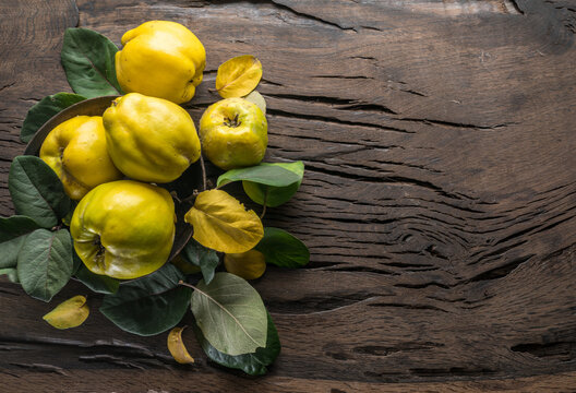 Ripe golden yellow quince fruits on wood. Organic fruits on old table. Top view.