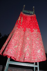 Bridel lehnga dress dress oicture standing with support behind the dress the amazing sky  
