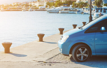 Blue car parked by the yacht bay